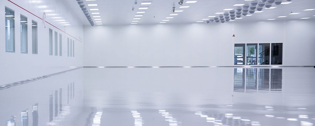 Ett tomt, högteknologiskt renrum med blankt golv och moderna installationer hos AMB Industri AB, redo för produktion inom medicinteknik eller andra känsliga områden.