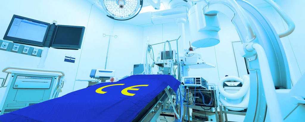 Operationssal med avancerad medicinteknisk utrustning – en brits täckt av ett blått skynke med gul CE-märkning symboliserar EU:s regelverk för medicinteknik.
